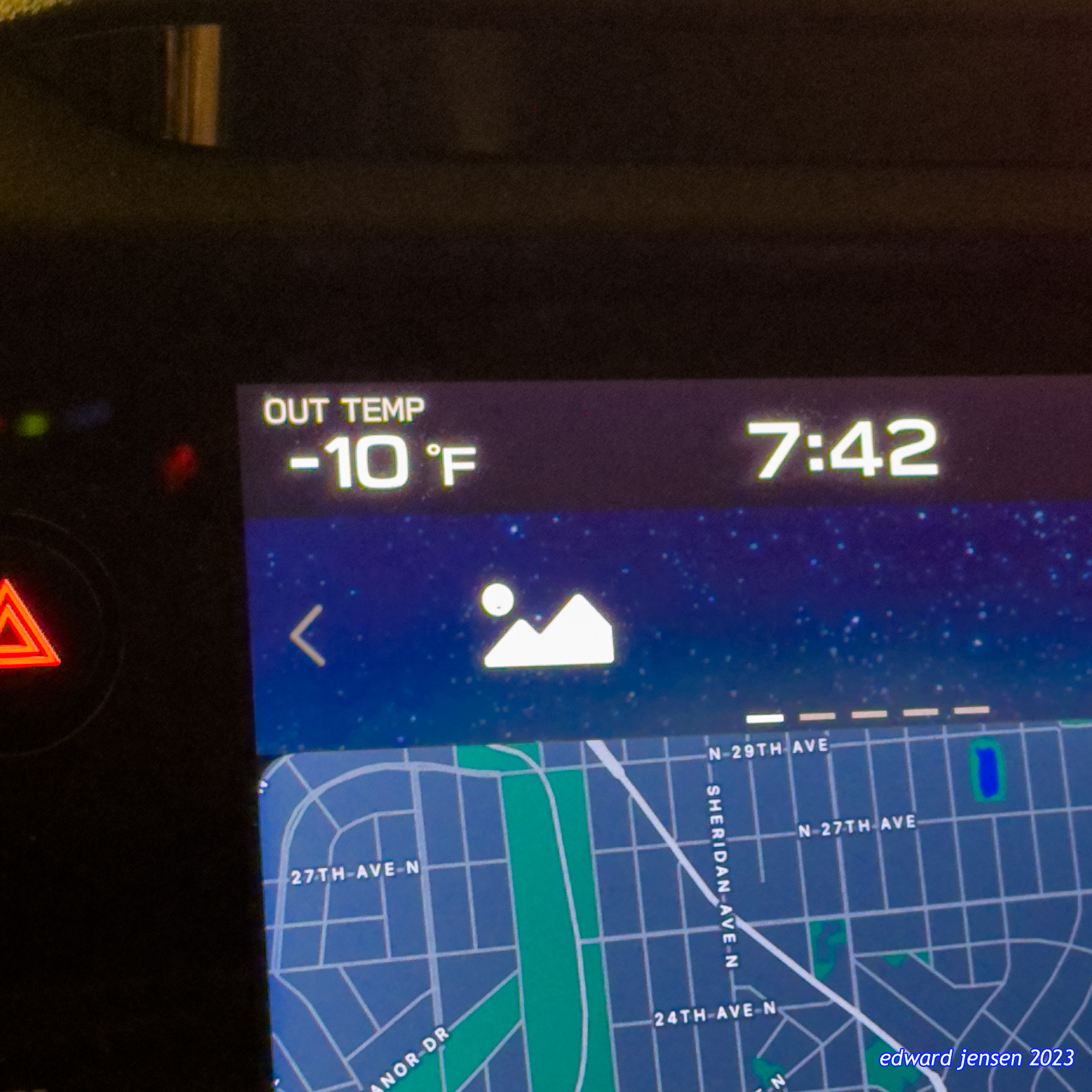 Car navigation system display showing a map of Minneapolis, Minnesota. The screen also shows outdoor temperature of -10°F and time 7:42. Map has blue background with white streets and a green area.