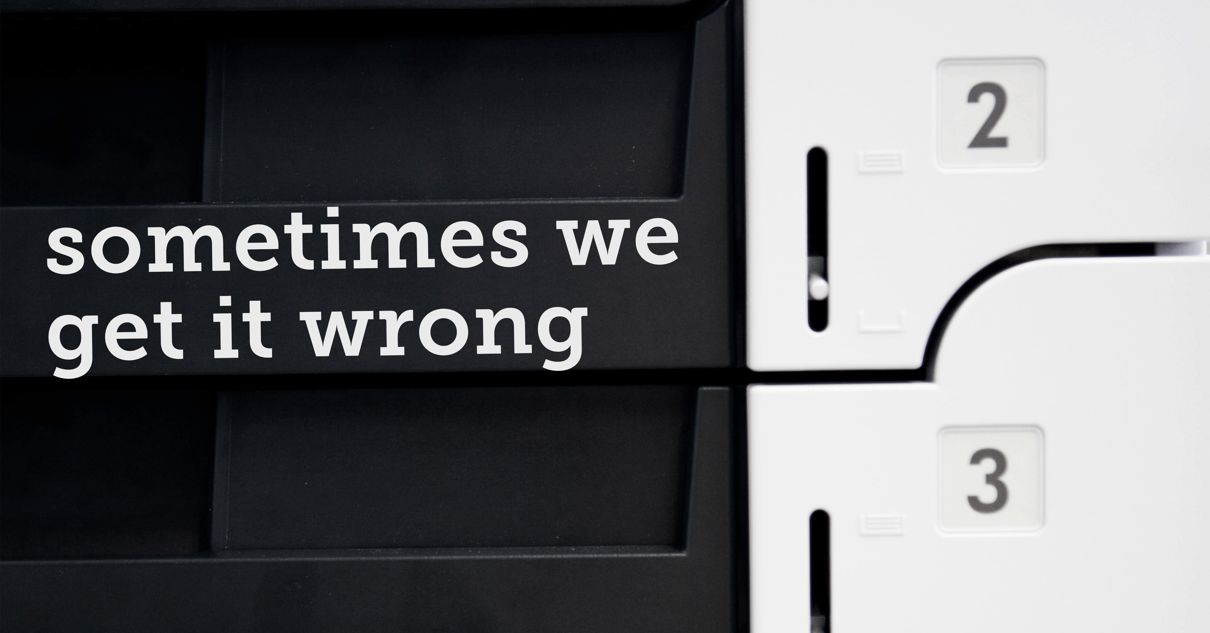 Close-up of several paper trays for a printer with numbered compartments (2 and 3 visible) and white text on a black background reading 