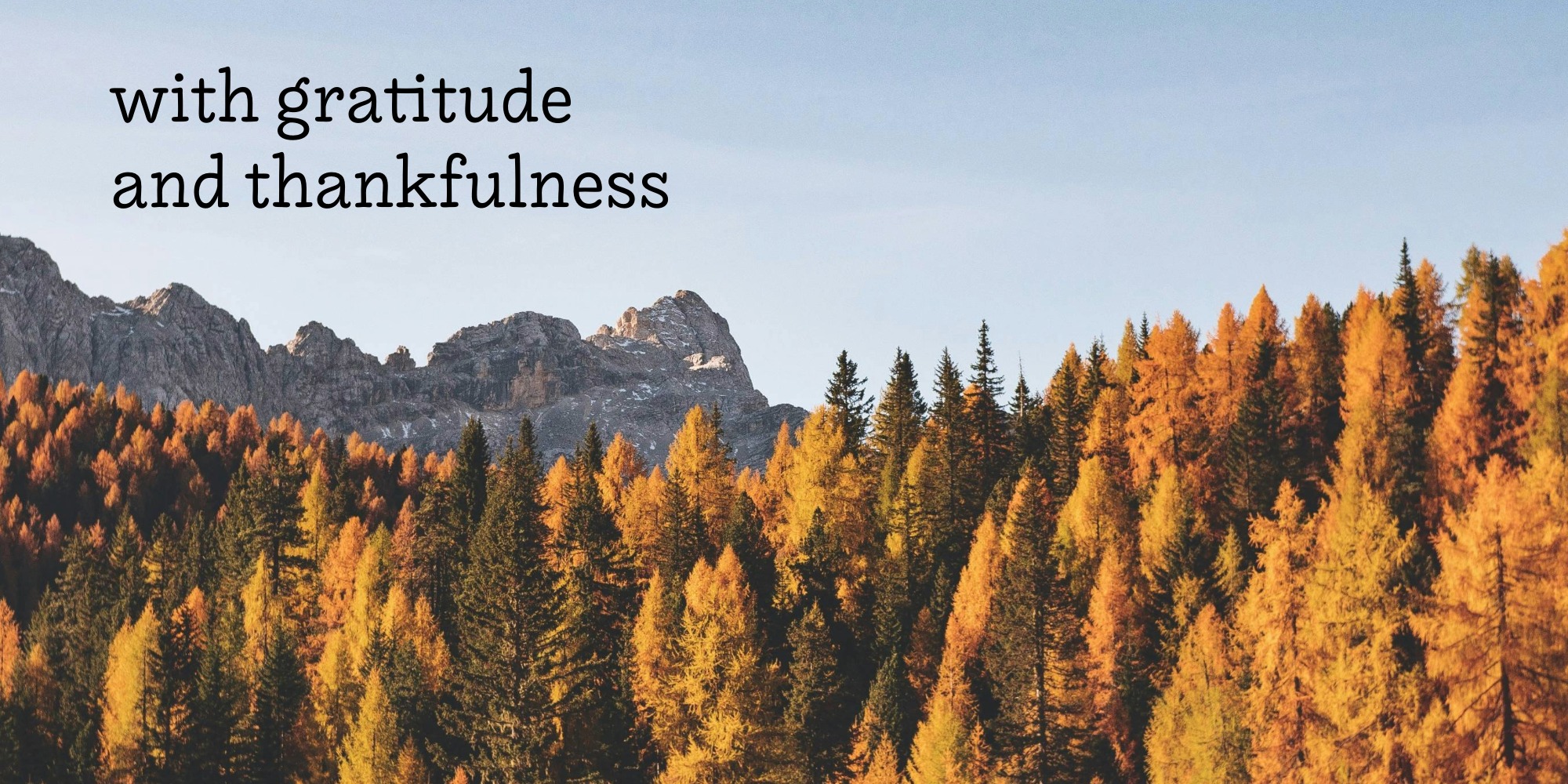 Autumn mountain landscape with golden larch trees in the foreground and rocky peaks against a clear blue sky, with the text 